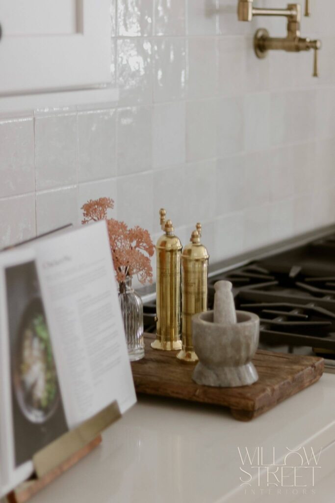 bright and airy white kitchen with zellige tile timeless brass fixtures and layered organic textures designed by interior design firm willow street interiors in Massachusetts